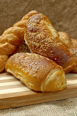 Fresh crunchy and warm home made bread on a wooden plate.