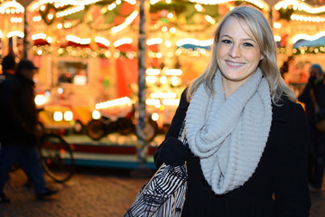 Frau auf Weihnachtsmarkt mit Karussell