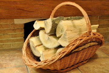 Fototapety  Firewood in a wicker basket in front of the fireplace