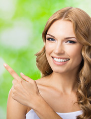 Naklejka premium Woman showing copyspace or something, outdoor