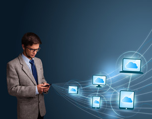 Handsome man typing on smartphone with cloud computing