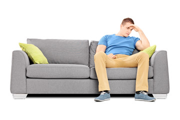 Dissappointed young man sitting on a sofa