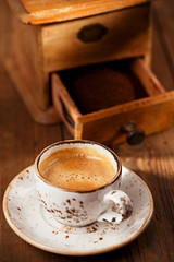 A cup of espresso coffee with Old coffee mill  textured table