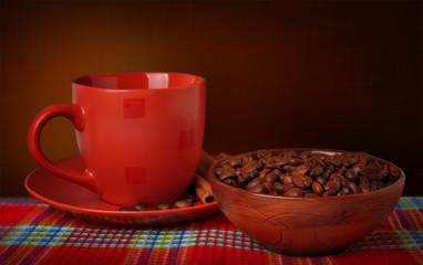 Coffee mug and coffee beans on a tablecloth on a dark background