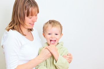 mother and child brushing teeth together