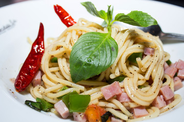 Spaghetti, ham on white dish