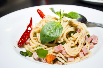 Spaghetti, ham on white dish