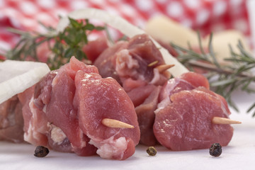 fresh pork skewers with vegetables, onions and rosemary