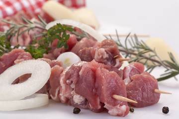fresh pork skewers with vegetables, onions and rosemary