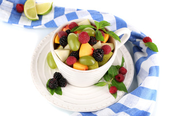 Fruit salad in cup near napkin isolated on white