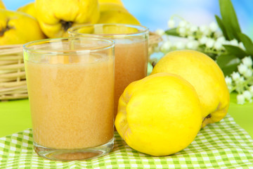 Sweet quince with juice on table on light blue background