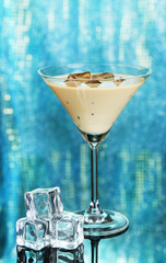 Baileys liqueur in glass on blue background