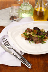 Fried chicken livers on plate on wooden table close-up