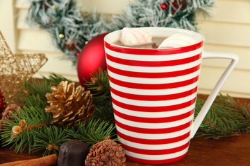 Cup of hot cacao with chocolates and Christmas decorations