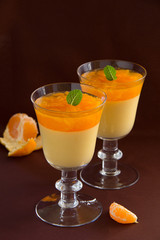 orange panna cotta with slices of oranges.