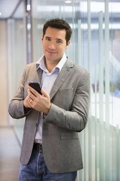Handsome Business man at the office on phone, sms, e-mail
