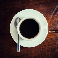 Black coffee in white cup on wooden