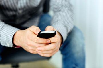 Closeup image of a male hand holding smartphone