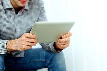 Closeup image of male hands holding tablet computer