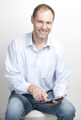 Smiling young man with tablet computer on white background