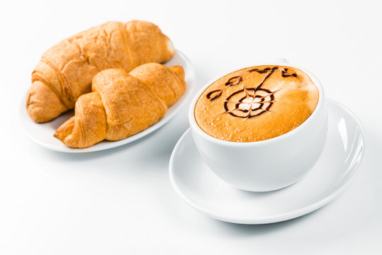 large cup of coffee and croissants on a plate