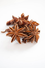 Star anise piled up on a white background.