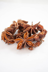 Star anise piled up on a white background.