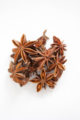 Star anise piled up on a white background.