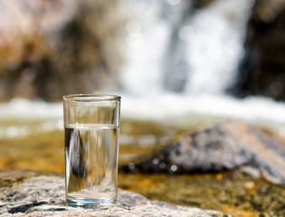 Glass of water by waterfall