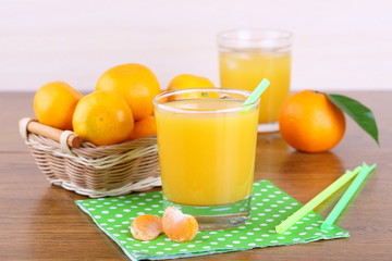 Glasses of fresh juice of tangerines and tangerines in a basket