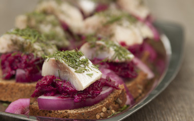 Canapes with herring fillet with beetroot, onions.