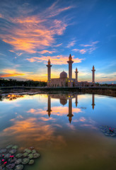 Fototapeta na wymiar Reflection of a mosque at sunrise in Shah Alam, Malaysia.