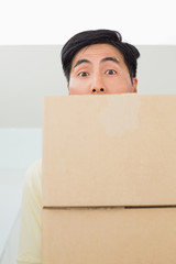 Close-up portrait of a young man carrying boxes