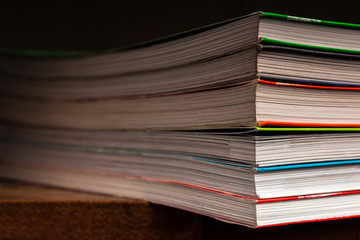 a stack of multicolored books on a dark background