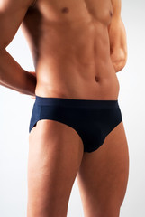 attractive male body fragment with blue underwear on white