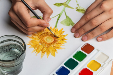 The artist paints a flower of watercolor