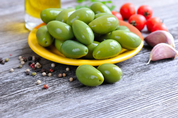 Green olives on a wooden background