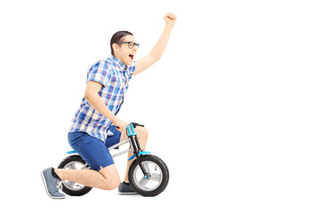 Excited guy riding a small bicycle and gesturing happiness