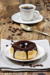 Delicious donut with chocolate on wooden table