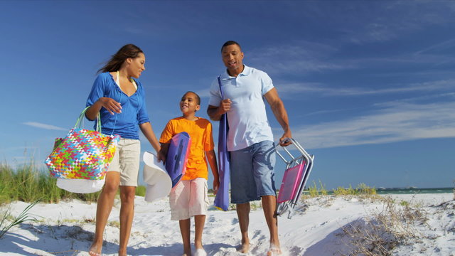 Happy African American Family Carrying Beach Equipment