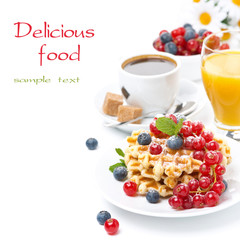 delicious breakfast with waffles, berries, orange juice
