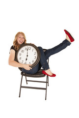 young woman holding a clock in chair with enthusiasm