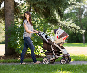 Beautiful Mother Pushing Baby Carriage In Park