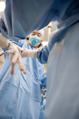 Female Nurse Assisting Doctor In Wearing Glove