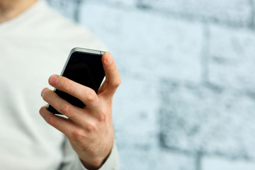 Closeup image of a male hand holding smartphone