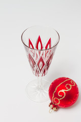 Champagne glass with red accents and Christmas bauble- isolated