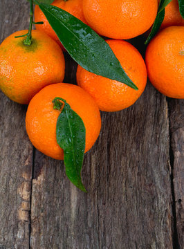 Tangerines with leaves on wooden table