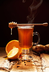 Winter tea with honey and orange on a wooden table
