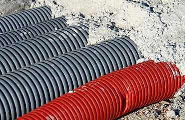 Red pvc corrugated hose and four gray pipes for laying electric
