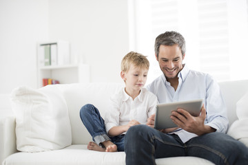 father and son playing on a tablet